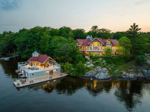 Aerial view of a Muskoka waterfront estate and boathouse at dusk